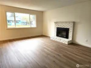 Living room with electric fireplace and new vinyl plank flooring