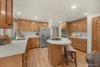 Spacious island kitchen with refinished hardwood floors, new quartz counters, SS appliances, walk-in pantry and eating bar