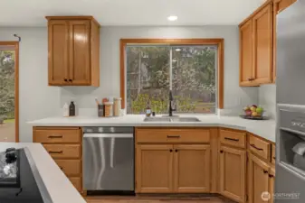 Large kitchen window looks out upon the lovely back yard