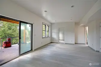 Another view of the main living area with slider to large composite deck, office straight ahead and exterior storage area to the right in the photo.