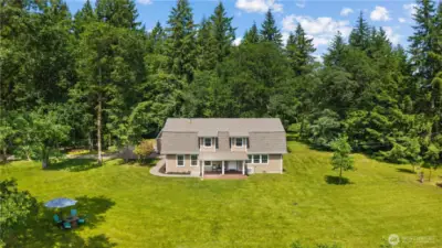 Peaceful & Private PNW Living  Nestled on over an acre and surrounded by towering evergreens, this charming home offers the ultimate in seclusion and serenity. With a large covered front porch, manicured lawn, and plenty of space for entertaining, it’s the perfect escape from the hustle while still being close to town.