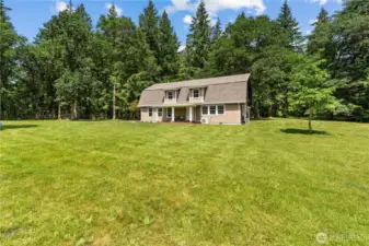 Full-Front View of Home Surrounded by Open Green Space  This clear, full-frontal view of the 2-story cabin-style home captures its balanced blend of rustic charm & modern functionality. Nestled against a backdrop of towering evergreens, the home sits centered in a wide open lawn—offering incredible curb appeal, privacy & usable space. Whether you envision hosting summer gatherings or simply enjoying the peace of nature, this Rochester retreat provides the space & serenity that Pacific Northwest buyers are searching for.