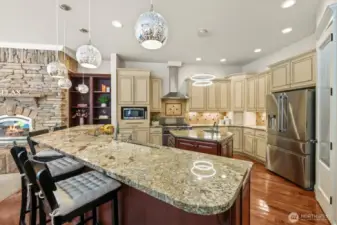 The refined kitchen has granite counters, wood floors, elegant lighting, prep island and stainless steel appliances!