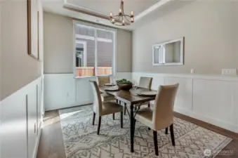 This formal dining area is large with great natural light and custom white-painted wainscotting designed to create an inviting area for all.