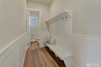 Entering this home from the garage area is also easy and inviting with this custom installed bench seating, coat hook and wainscotting plus a conveniently located half bathroom