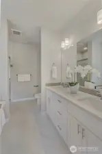 A primary bathroom that incorporates efficient, partitioned areas with custom tile and trim accents