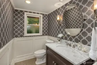Powder room. Designer wallpaper makes a fun statement. This is located in the hall between the living room and kitchen/family room.