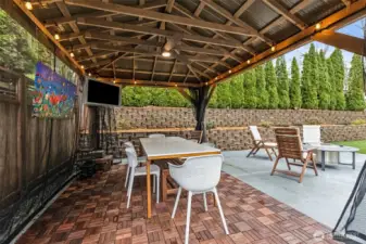 Call this your backyard VIP section. Parquet-style tile flooring sets the tone, the mounted TV stays for instant entertainment, and the bug netting lets you decide how open or cozy you want the space. There’s a ceiling fan to keep things breezy and lighting that carries you straight into evening without packing it in early. It’s set up for everything from quiet lounging to full-on hosting, no extra effort required.