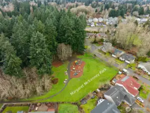 Right across the cul de sac, you’ve got Margaret McKenny Park, and this is not some tiny patch of grass pretending to be a park. It’s a full 4 acre City of Olympia park with trails, loops, basketball court, playground, swings, and picnic spots that actually get used. There’s a really cool backstory here too, Margaret McKenny helped save local watershed land from development back in the 1950s, so this space exists because someone fought for it. From the aerial you can see how close it is, yet the home still feels tucked in thanks to a buffer of evergreens. It’s that sweet spot of having something to do steps away, without it feeling like it’s in your backyard.
