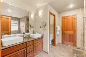 This primary bath knows exactly what it’s doing. Tile floors ground the space, while the granite counters and those raised vessel sinks bring a little drama in the best way. Two sinks, so no one’s elbowing for space, a separate toilet water closet for privacy, and a layout that just flows right when you’re getting ready.