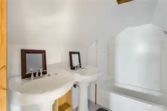 Primary bathroom attached to upstairs loft-style bedroom with dual sinks