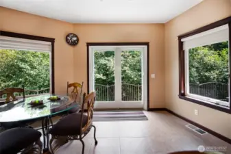 The kitchen dining nook is surrounded by light from all the windows, and the french doors exit onto the large concrete deck that runs the width of the back of the home. The flow of food and entertainment from this kitchen to the dining room, the living area, and the outdoor entertaining space is perfect.