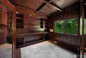 The wood tones and window create the ideal atmosphere for an office, library, or study.