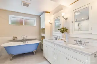 Spa-like primary bathroom with double vanity, Carera marble countertops, and clawfoot tub.