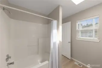 Ensuite bath with window and soaking tub for natural light and comfort