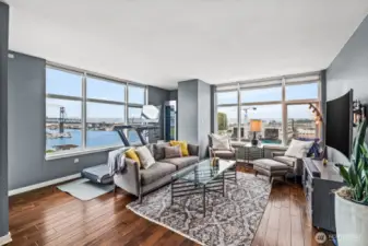 The 11th Street Bridge is shown outside the window on the left. The space behind the sofa is being used here as a fitness nook, with a wine cabinet in the corner. This is also an ideal space for a home office.