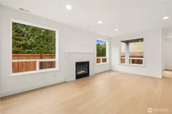 This bright main-level living area features wide plank engineered hardwoods, large picture windows framing the private fenced yard, and a sleek gas fireplace with a modern stacked-stone surround. The open layout creates a seamless flow into the kitchen and dining spaces, perfect for relaxed Eastside living and effortless entertaining.These photos are from Lot 3 at Gooden Hollow, which is the same floorplan. However, Lot 6 will have changes, so all photos, renderings, site maps, and floorplans are for visualization purposes only. Plans, colors, building orientation, finishes, home outlook, and other details can and WILL vary.