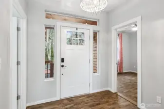 Front entrance lets in lots of natural light! Guest bedroom on your right and laundry room on your left