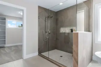 A frameless glass shower is a work of art creating a decadent atmosphere.  The dual function shower includes floor to ceiling tiling and a decorative inlaid shower shelf where shower essentials can be stored.