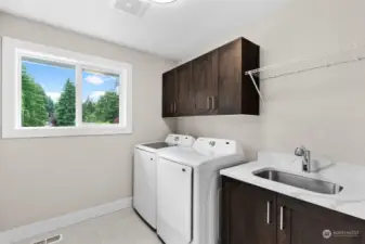 Steps from the bedrooms, this upper level laundry room is equipped with upgraded quartz, tile, and a top loader washer and dryer for ultimate convenience!