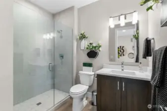 Step into elegance with this main floor bathroom, complete with a modern tile mud pan and frameless shower door.