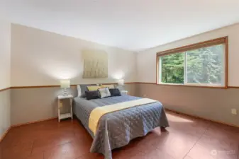 Spacious primary bedroom maintains the cork floors, large window to side yard.