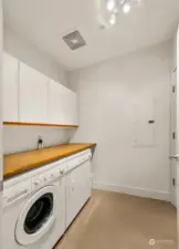 Laundry room has a generous folding table, dryer is gas and plenty of storage behind the door and in the cabinets