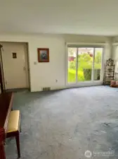 View of the entry, living room and the wall of windows it offers, lots of natural light