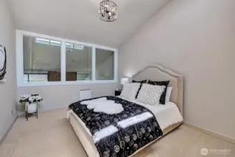 Primary bedroom with vaulted ceiling and new windows overlooking living room