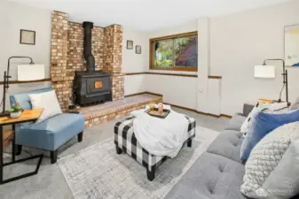 Another view of the bonus room showcasing a charming wood stove fireplace.