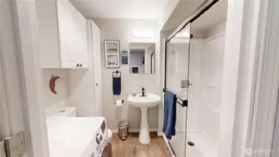 Lower level 3/4 bathroom with all in one washer dryer.