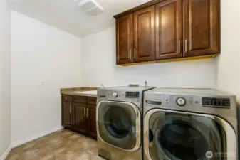 Laundery room on upper level with sink and storage vabinets