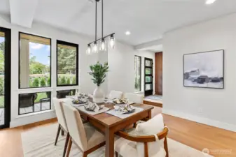 This dining room offers a bright, stylish setting perfect for hosting intimate dinners or festive gatherings. With natural light streaming through the windows and a modern chandelier overhead, the space feels both inviting and refined for entertaining guests.