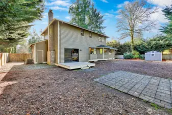 Spacious, fully fenced backyard with a concrete paver patio for a firepit (maybe?) and a wood deck off the family room.