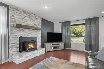 View of your family room from dining, wall-to-ceiling stone fireplace! Gorgeous, love the flooring and large windows as well.