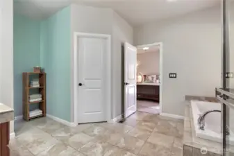 Bath room off primary with large closet and ceramic tile flooring.
