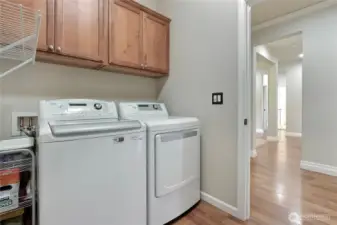 Cove moldings in hall by laundry and primary bedroom.