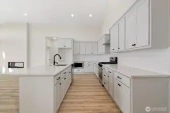 Giant kitchen with custom cabinets and gas range.