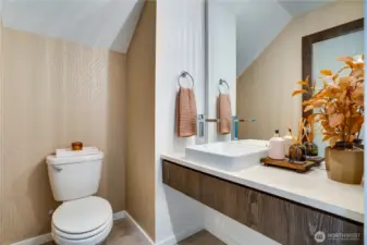 Main-floor powder room refreshed with stylish new wallpaper and sleek floating vanity.