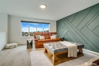 Upstairs landing bonus room / media room with wood wall art.