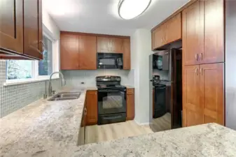 Kashmir white slab granite countertops with tile backsplash, dark cherry custom cabinetry & new lighting.