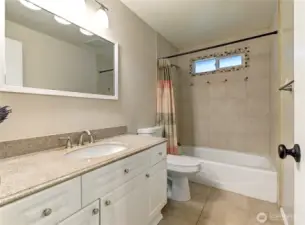 Upper-level Bathroom w/ tile flooring, tile-surround shower, soaker tub, granite vanity & new paint/lighting.
