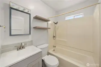 Full bath located between the two bedrooms with updated vanity, mirror, and toilet.