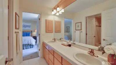 Jack and Jill bathroom with dual sinks and separate tub/toilet space