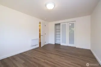 First bedroom with large closet area and attractive closet doors with built in shelving.  The luxury vinyl plank flooring is consistent from one room to the next - attractive, durable, easy to maintain, and no thresholds!