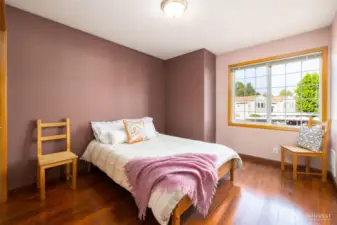 Bedroom with closet, hardwood laminate floors throughout.