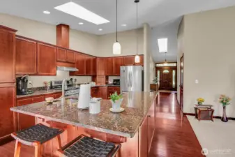 The kitchen shines with a skylight, breakfast bar, and abundant natural and overhead lighting.