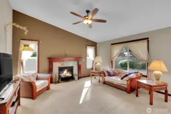 Great room boasts vaulted ceilings, fireplace, and open connection to kitchen.