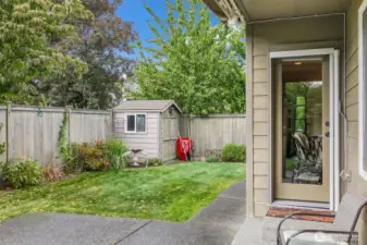 Step outside to the patio and fenced backyard, featuring a handy storage shed for tools or toys.