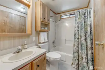 Guest bathroom has tiled floors, new bathtub/shower combo.